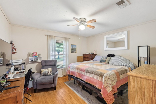 bedroom featuring ceiling fan, crown molding, and light hardwood / wood-style floors