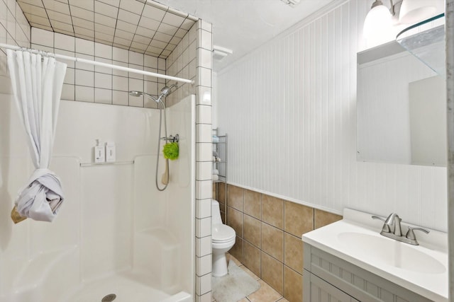 bathroom with toilet, tile patterned flooring, walk in shower, and vanity