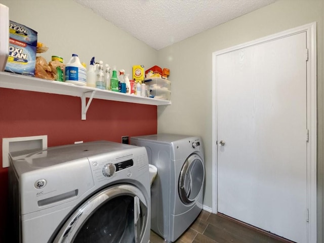 laundry area featuring a textured ceiling, separate washer and dryer, and dark hardwood / wood-style flooring