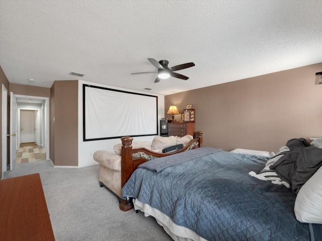 carpeted bedroom featuring ceiling fan and a textured ceiling