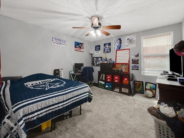 carpeted bedroom featuring ceiling fan and a textured ceiling