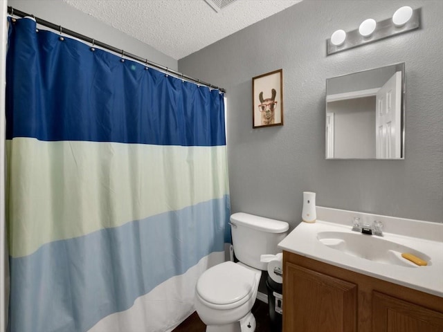 bathroom featuring a textured ceiling, toilet, and vanity