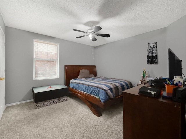 bedroom with ceiling fan, a textured ceiling, and light carpet