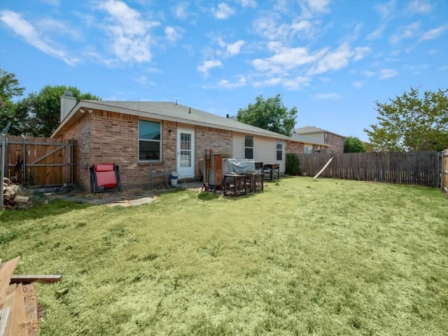 rear view of property with a yard