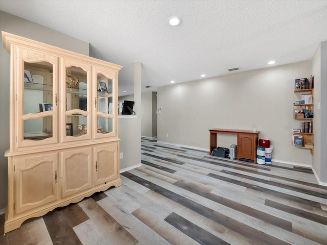 bar with hardwood / wood-style flooring and a textured ceiling