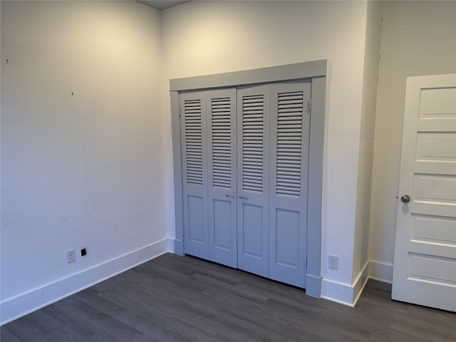 unfurnished bedroom featuring dark hardwood / wood-style flooring and a closet