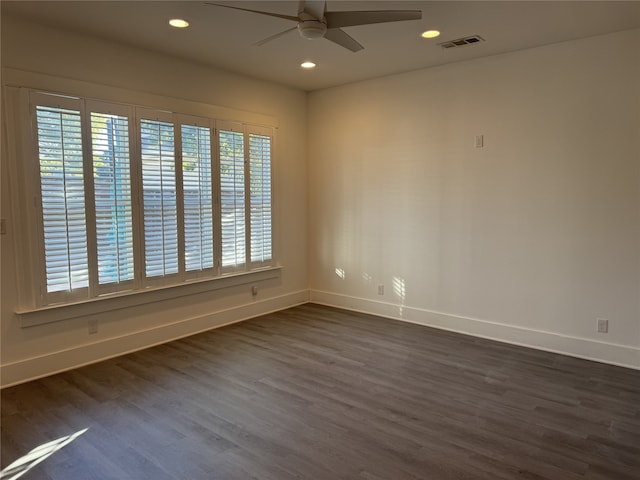 empty room with ceiling fan and dark hardwood / wood-style flooring