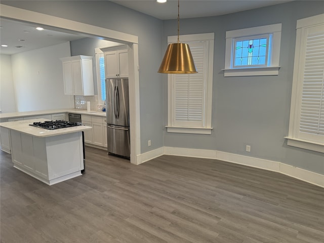 kitchen featuring black appliances, decorative backsplash, kitchen peninsula, wood-type flooring, and white cabinets