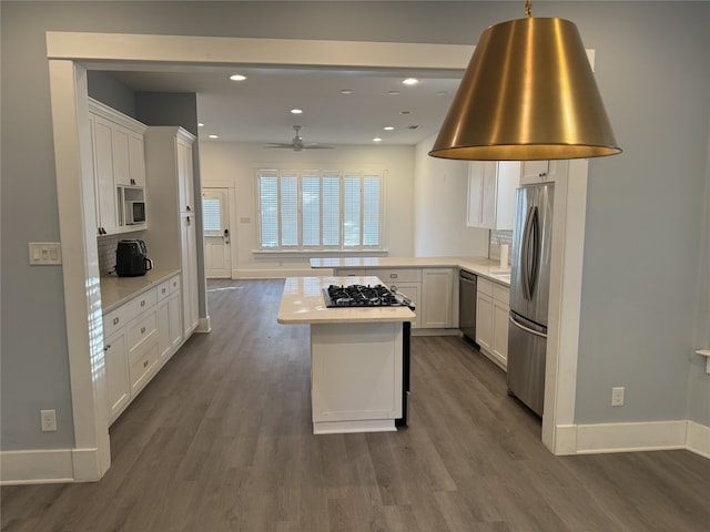 kitchen featuring white cabinetry, dark hardwood / wood-style flooring, stainless steel appliances, and tasteful backsplash