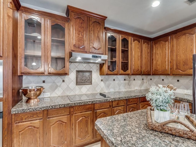 kitchen with light stone countertops, backsplash, and black electric cooktop