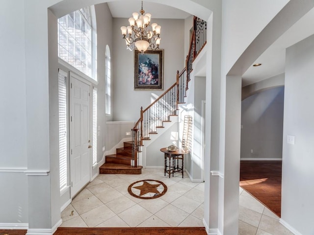 tiled entryway with a notable chandelier