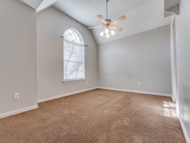 carpeted empty room featuring ceiling fan, plenty of natural light, and vaulted ceiling