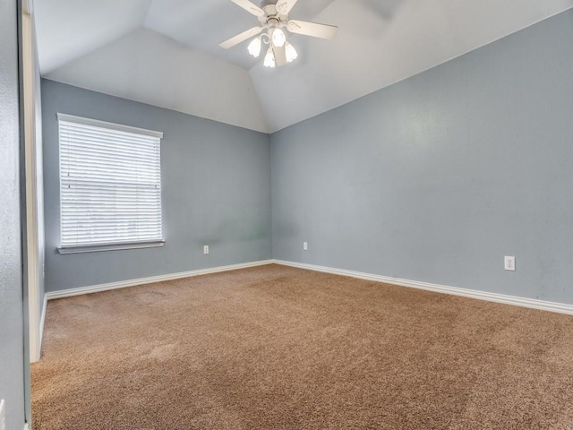 carpeted spare room with ceiling fan and vaulted ceiling