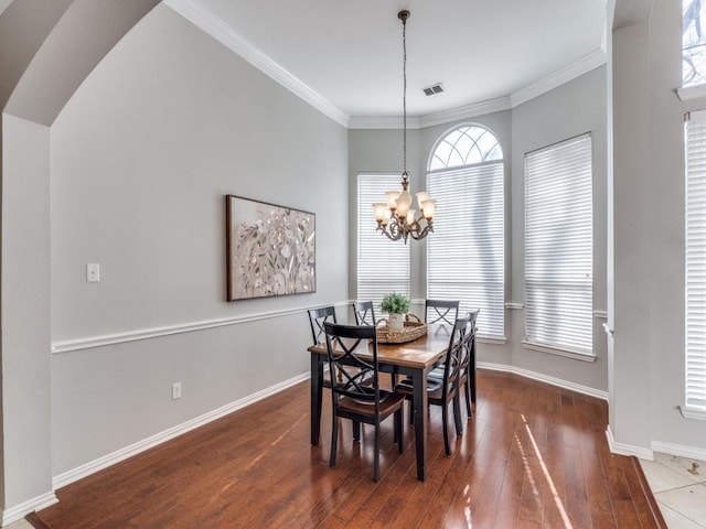 dining room featuring crown molding, an inviting chandelier, and dark hardwood / wood-style floors