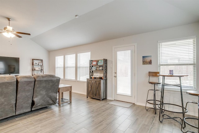 living room with lofted ceiling, ceiling fan, and a healthy amount of sunlight