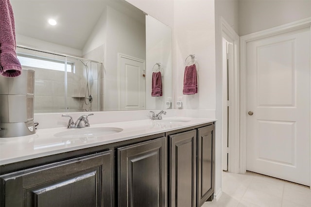 bathroom with a shower with shower door, vanity, tile patterned floors, and lofted ceiling