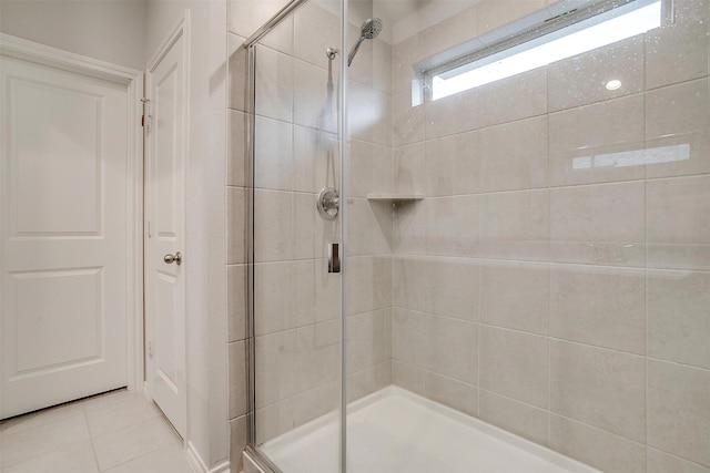 bathroom with a shower with shower door and tile patterned flooring