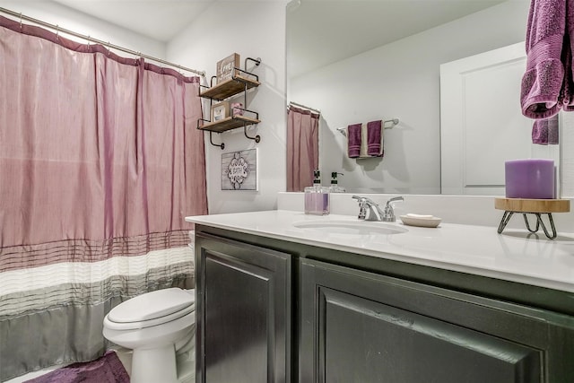 bathroom featuring toilet, vanity, and a shower with curtain