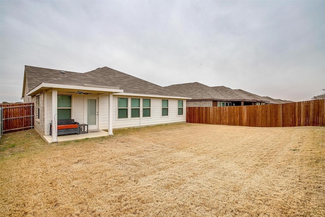 back of house featuring a lawn and a patio