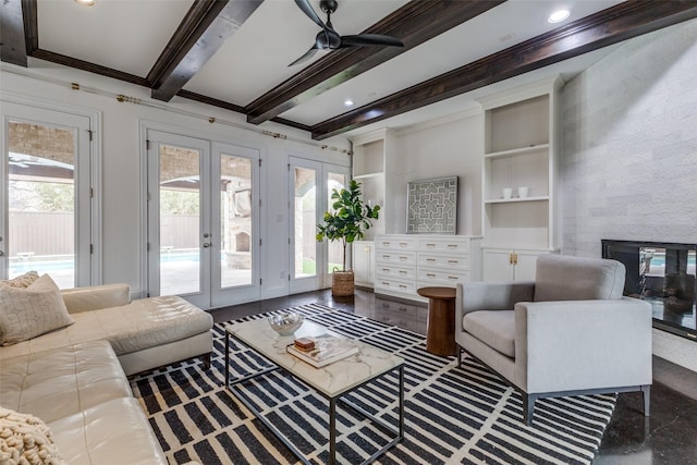 living room with french doors, built in features, beam ceiling, a fireplace, and ornamental molding