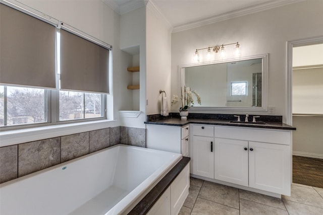 bathroom with tile patterned floors, vanity, crown molding, and a bathing tub