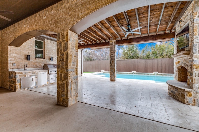 view of patio / terrace featuring a grill, ceiling fan, an outdoor stone fireplace, and area for grilling