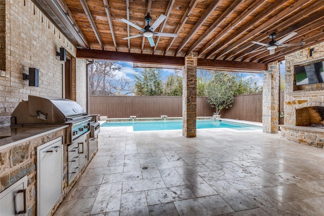 view of patio with ceiling fan, a fenced in pool, an outdoor stone fireplace, and area for grilling