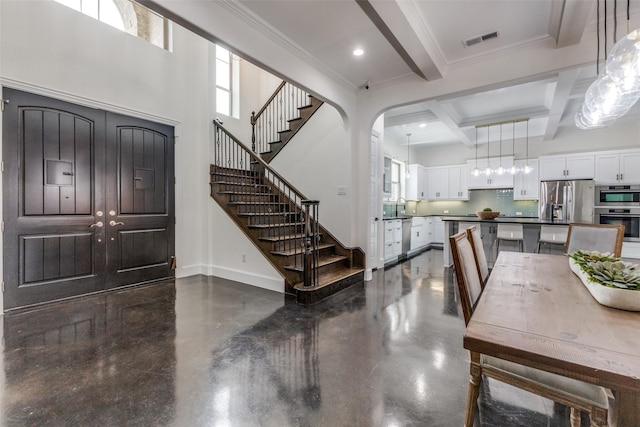 foyer with ornamental molding, coffered ceiling, beam ceiling, and sink