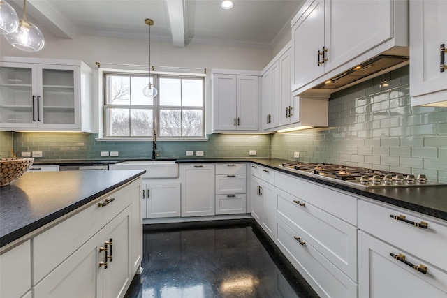 kitchen featuring pendant lighting, sink, premium range hood, white cabinets, and stainless steel gas cooktop