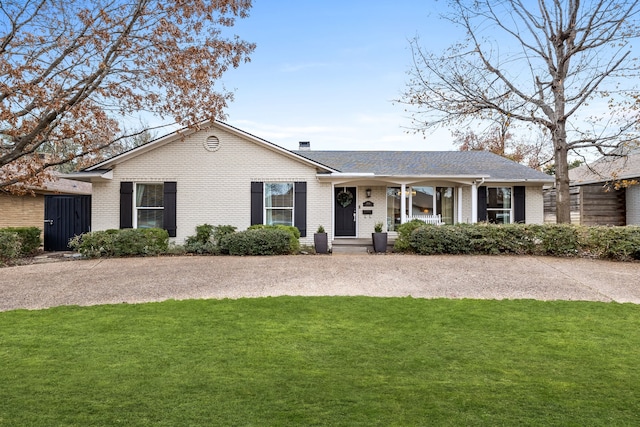 ranch-style house featuring a front lawn and covered porch