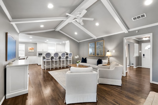 living room with ceiling fan, vaulted ceiling with beams, dark wood-type flooring, and ornamental molding