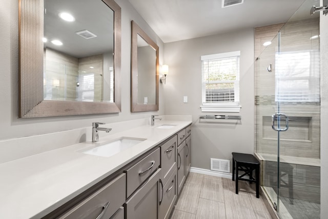 bathroom featuring a shower with shower door and vanity