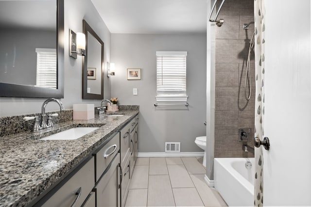 full bathroom with tile patterned floors, toilet, vanity, and a healthy amount of sunlight