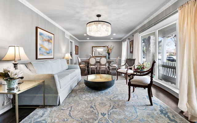 living room featuring wood-type flooring, a notable chandelier, and ornamental molding