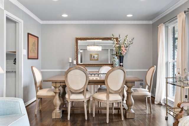 dining space featuring dark wood-type flooring, crown molding, and a chandelier