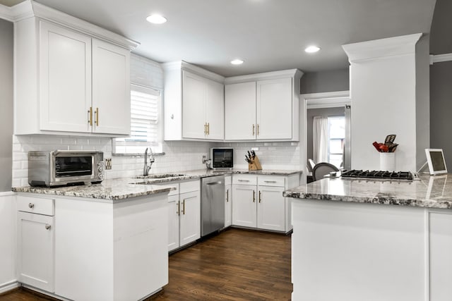 kitchen featuring white cabinetry, stainless steel appliances, dark hardwood / wood-style floors, light stone countertops, and sink