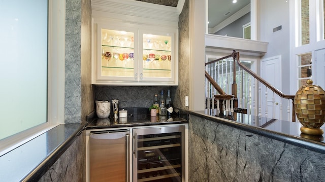 bar with a healthy amount of sunlight, decorative backsplash, beverage cooler, and fridge