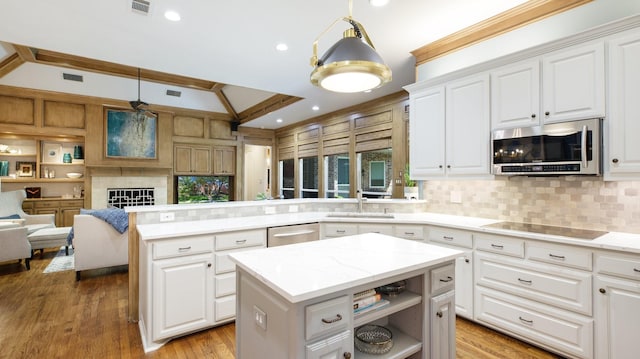 kitchen featuring a center island, sink, hanging light fixtures, appliances with stainless steel finishes, and white cabinets