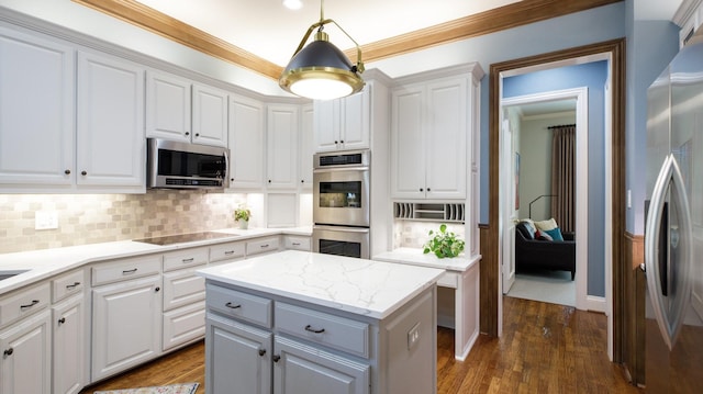 kitchen with appliances with stainless steel finishes, decorative backsplash, white cabinetry, and hanging light fixtures