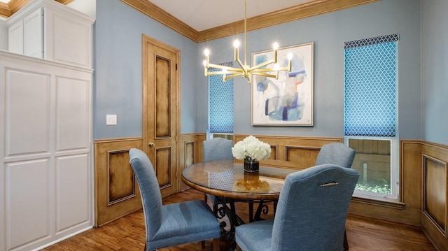 dining area with a chandelier, ornamental molding, and hardwood / wood-style floors