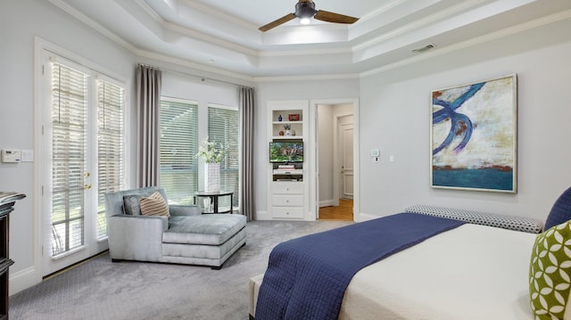 carpeted bedroom with ceiling fan, multiple windows, a raised ceiling, and access to outside