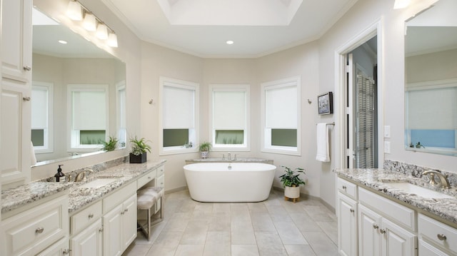 bathroom with a tub to relax in, vanity, ornamental molding, and tile patterned flooring