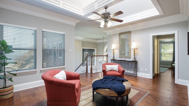 living area with dark hardwood / wood-style flooring, crown molding, and a healthy amount of sunlight