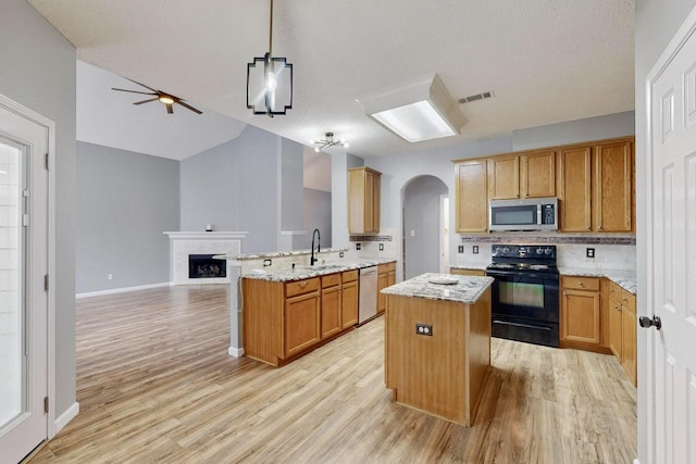 kitchen with sink, a center island, kitchen peninsula, pendant lighting, and stainless steel appliances