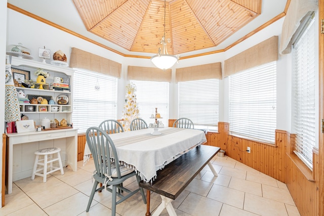 dining room with wooden ceiling, light tile patterned floors, crown molding, and wooden walls