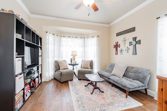 living room featuring ceiling fan, wood-type flooring, and crown molding