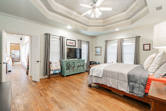 bedroom featuring ceiling fan, ornamental molding, and a raised ceiling