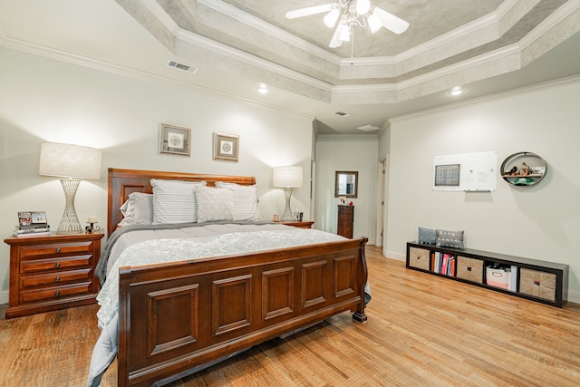 bedroom with ceiling fan, ornamental molding, and a raised ceiling