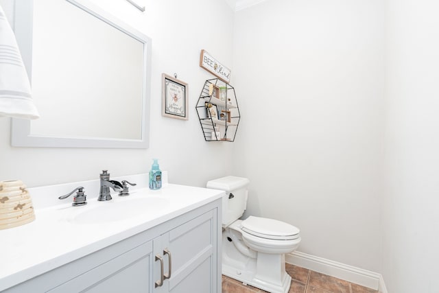 bathroom with toilet, vanity, and tile patterned floors