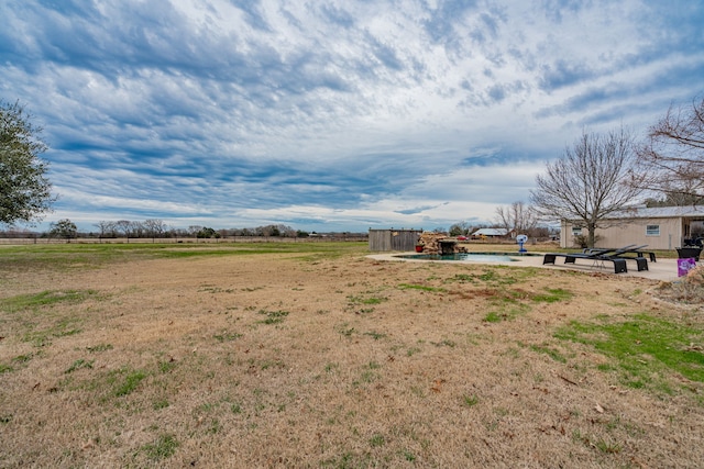 view of yard featuring a rural view and a pool